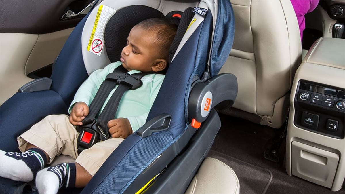 Dark-skinned baby sleeps in a car seat installed in a vehicle. Image from Consumer Reports Magazine